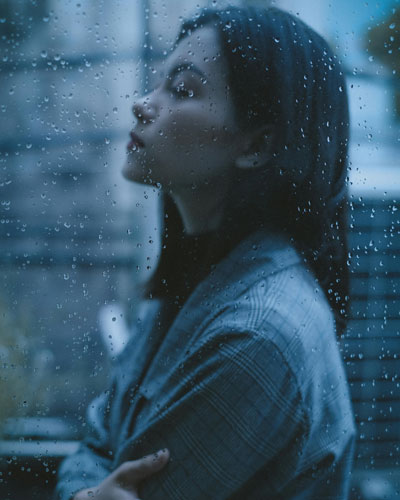 A teenage girl sitting alone, looking down with a sad expression, illustrating relationship difficulties in teenagers.