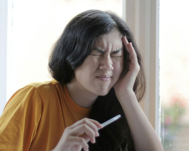 A school girl sitting at her desk with a furrowed brow, concentrating hard on her homework, illustrating the challenge of focusing in school-going kids.